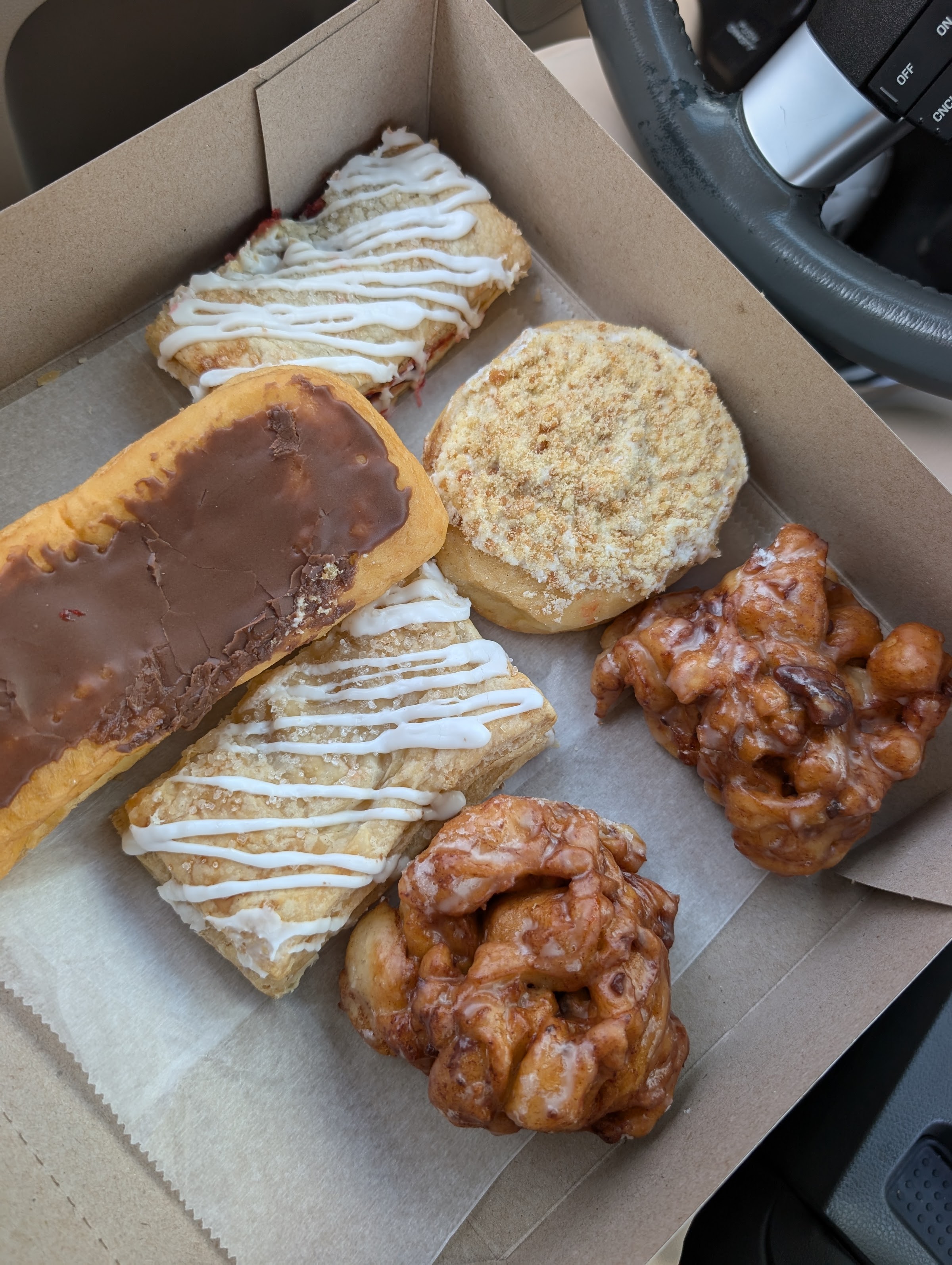 Apple fritters, a chocolate long john, and crumb-topped pastries